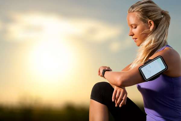 Image shows a woman using a heart rate monitor to track her hiit workout. She has competed her workout using heart rate training zones to maximise her intensity.