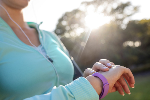 Image shows a woman training using a health smart watch to monitor her intensity.