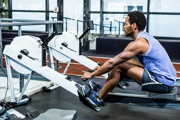 Best heart rate monitor for rowing is depicted by an athlete training his heart rate on a rowing machine.